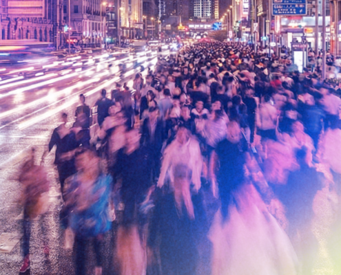 Large crowd moving through a busy city street at night, symbolizing the broader communities lawyers serve through public service, advocacy, and access to justice initiatives.