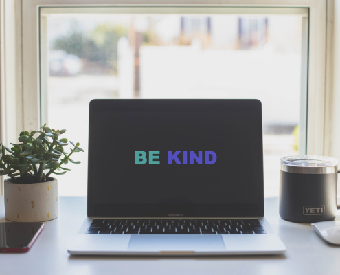 be kind in green and blue on laptop screen