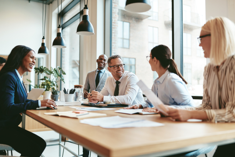 team working together smiling at conference table