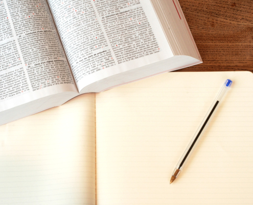 book and empty notebook with pen
