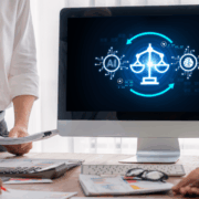 Three legal professionals standing around a desk reviewing documents while a computer screen displays an AI and justice scales graphic, representing the use of artificial intelligence in legal work.