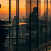 An image of a man working in an office at the top of a skyscraper.