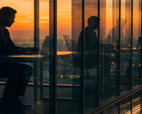 An image of a man working in an office at the top of a skyscraper.
