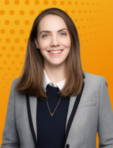 Portrait of a smiling female legal executive (Sarah Wilson)in a gray blazer against an orange background.