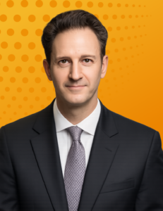 Portrait of a male legal executive (Fabio Bertoni) in a dark suit and tie against an orange background.