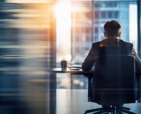General counsel seated alone at a conference table in a modern office, representing the responsibility of earning executive trust in a new leadership role.